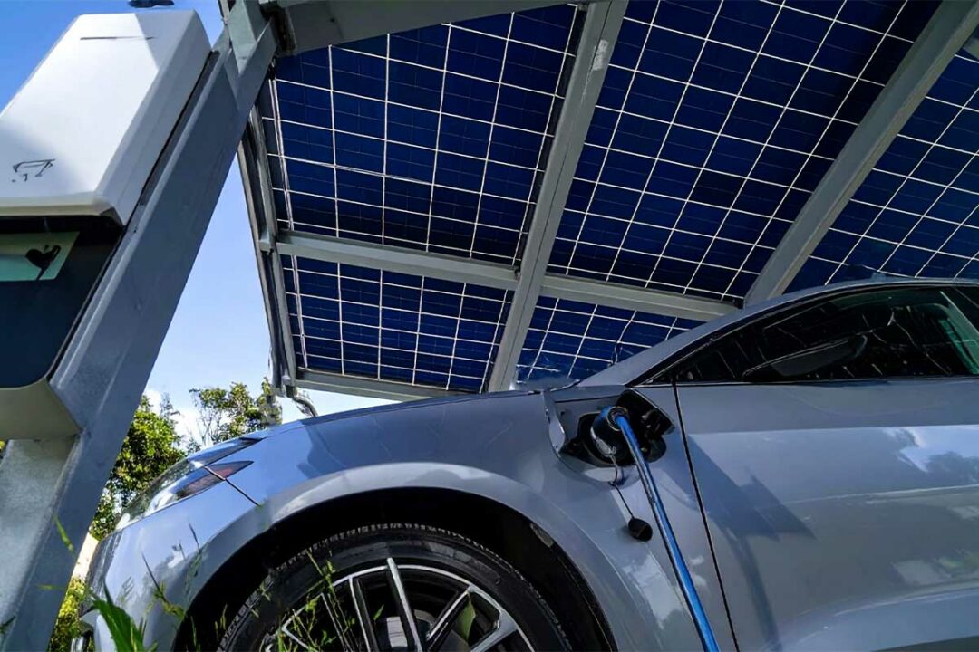 Une voiture électrique garée sous un carport solaire en recharge.