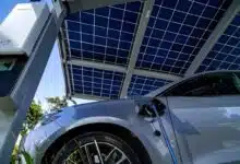 Une voiture électrique garée sous un carport solaire en recharge.