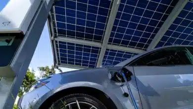 Une voiture électrique garée sous un carport solaire en recharge.