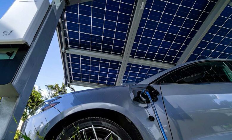 Une voiture électrique garée sous un carport solaire en recharge.