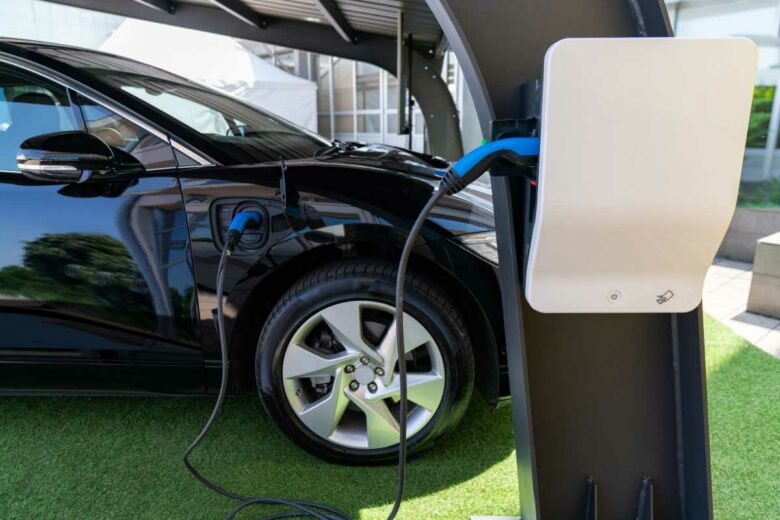 Une voiture se recharge sous un carport.
