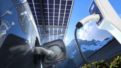 Une voiture électrique recharge sous un carport solaire.