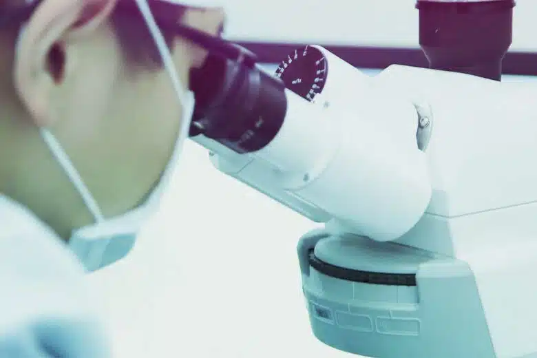 Un scientifique regarde dans un microscope.