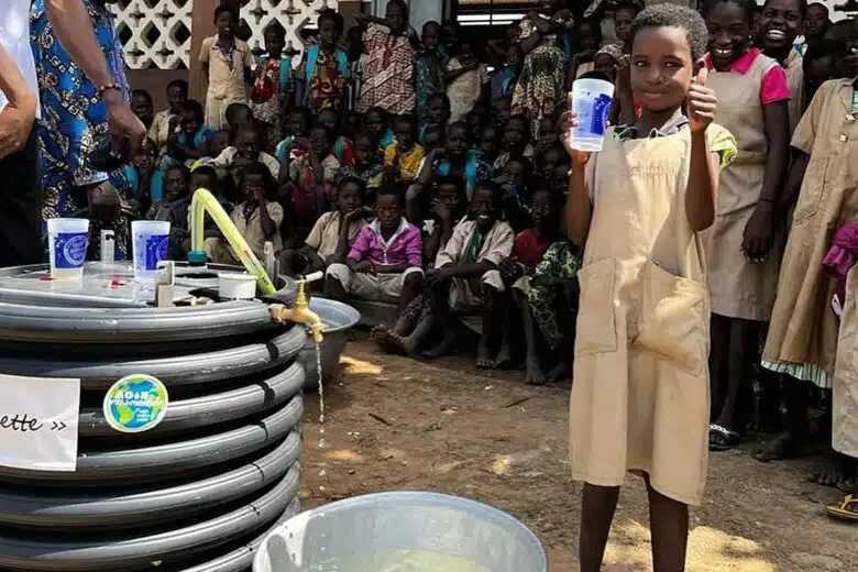 Un enfant avec un verre d'eau filtrée.