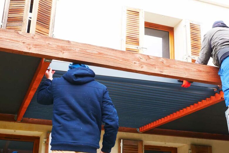 Deux hommes montent une pergola.