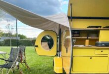 Une mini caravane rétro avec un auvent.