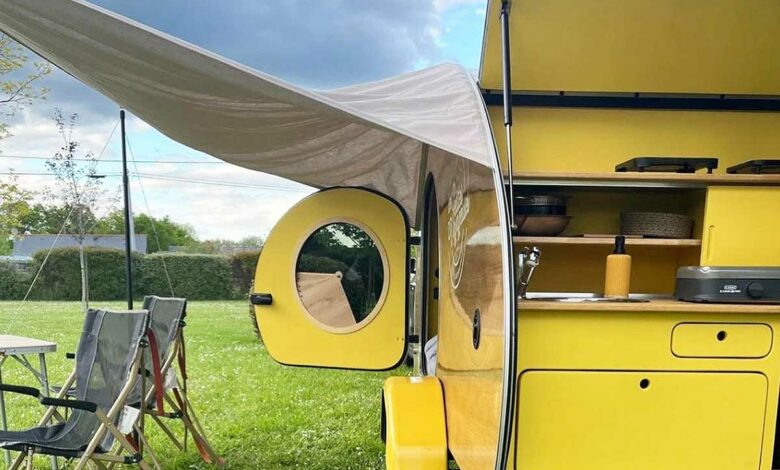 Une mini caravane rétro avec un auvent.