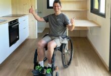 Une personne en fauteuil roulant dans une tiny house.