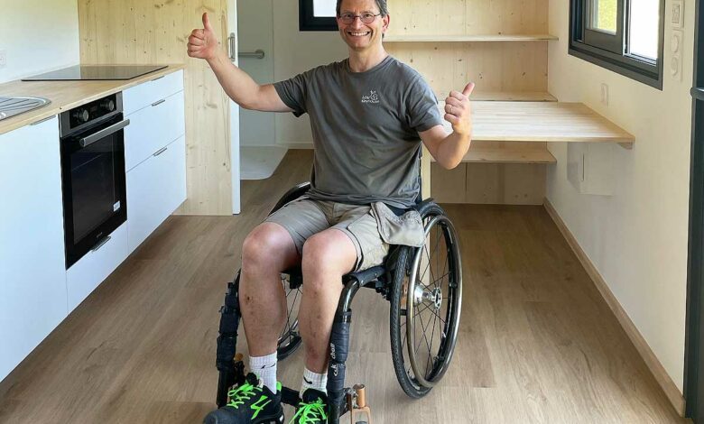 Une personne en fauteuil roulant dans une tiny house.