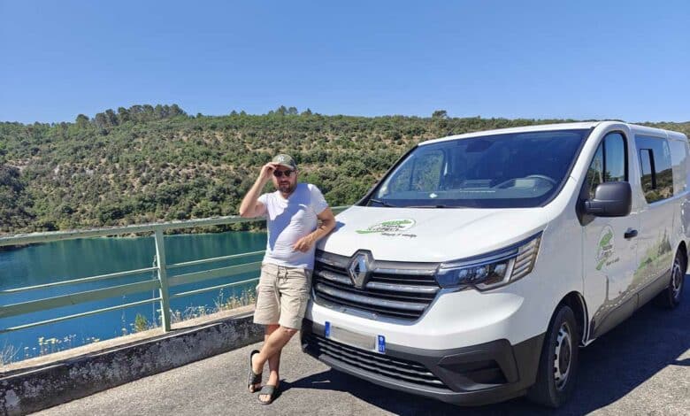Un homme devant son van aménagé.