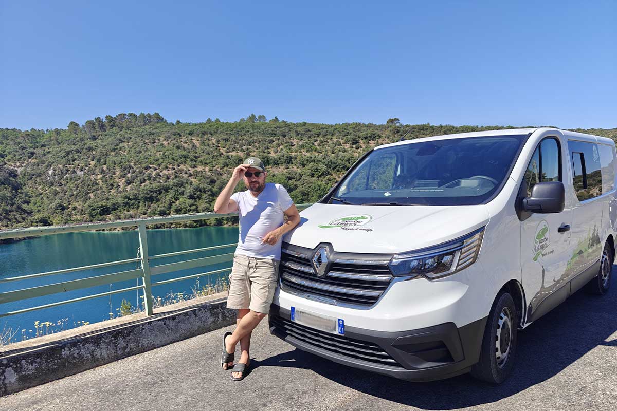 Un homme devant son van aménagé.