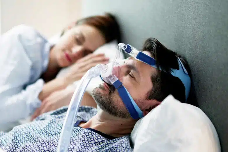 Un homme équipé d'un dispositif contre l'apnée du sommeil.