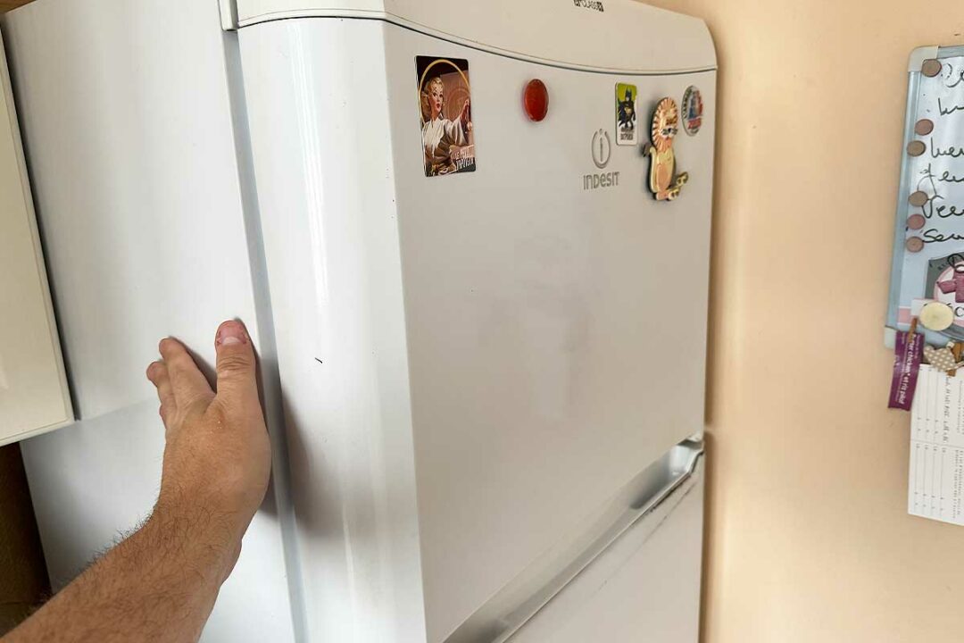 La main sur une paroi de frigo.