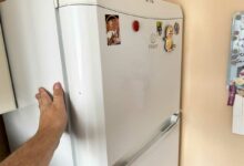 La main sur une paroi de frigo.