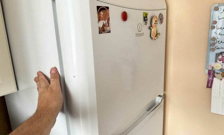 La main sur une paroi de frigo.