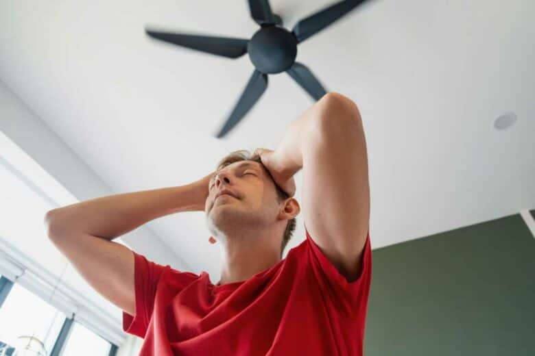 Un homme sous le ventilateur de plafond.
