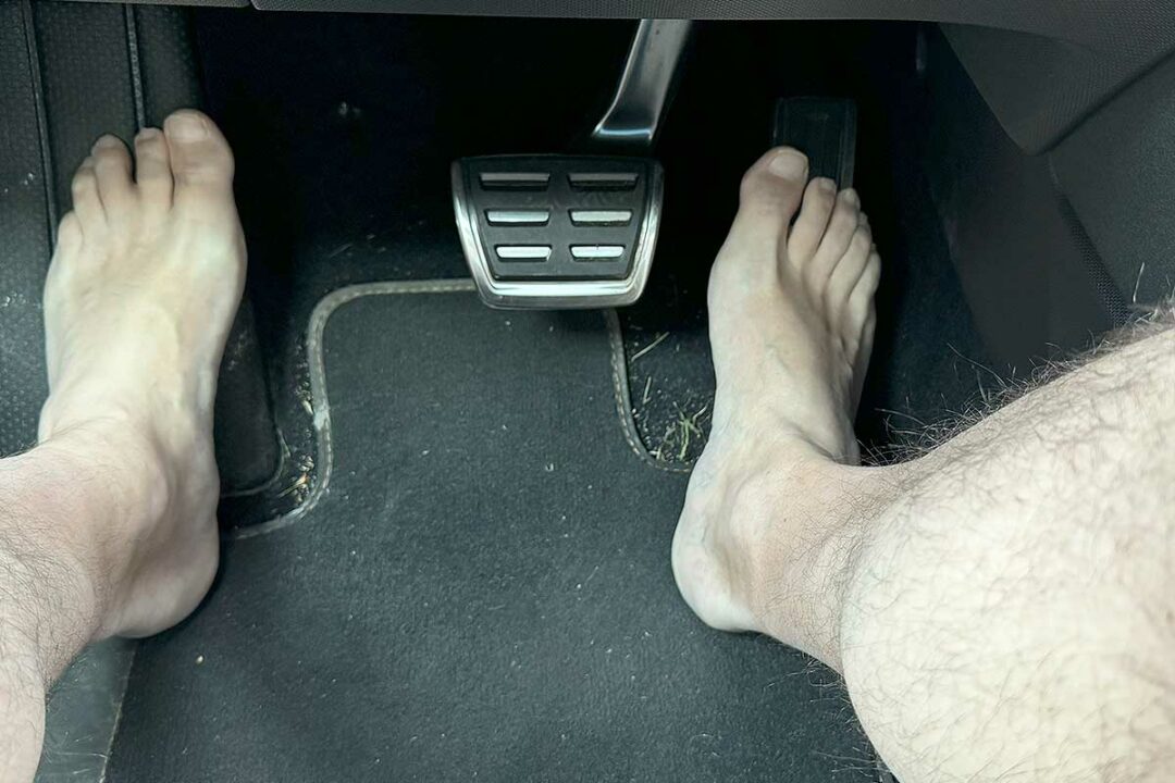 Un homme pieds nus qui conduit.