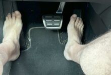 Un homme pieds nus qui conduit.