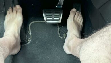 Un homme pieds nus qui conduit.
