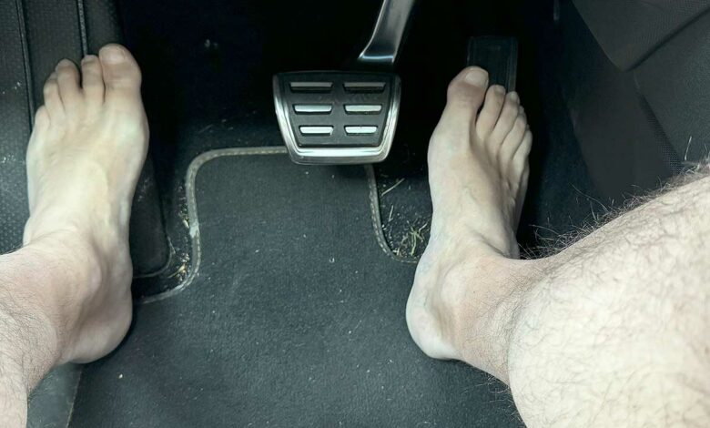 Un homme pieds nus qui conduit.