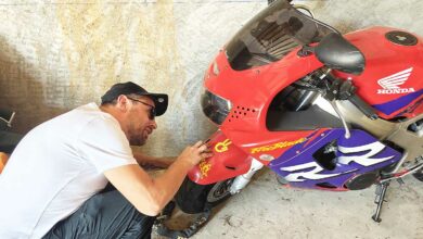 Un motard inspecte son véhicule.