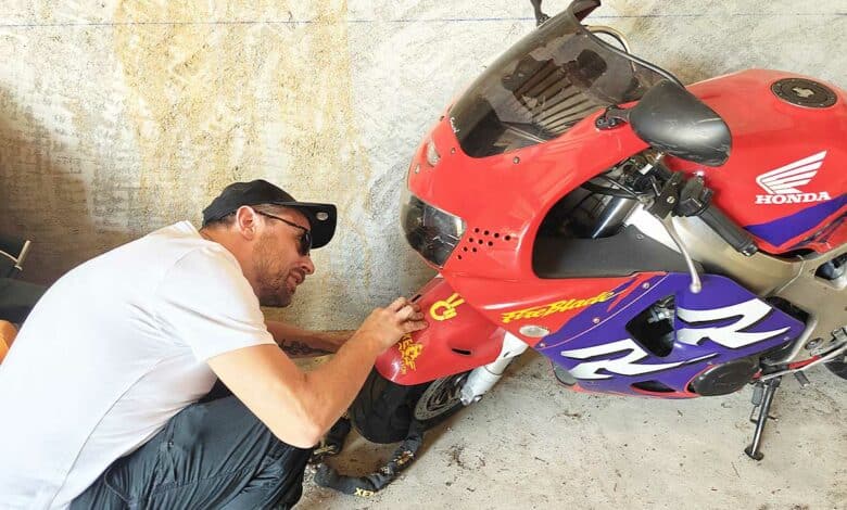 Un motard inspecte son véhicule.