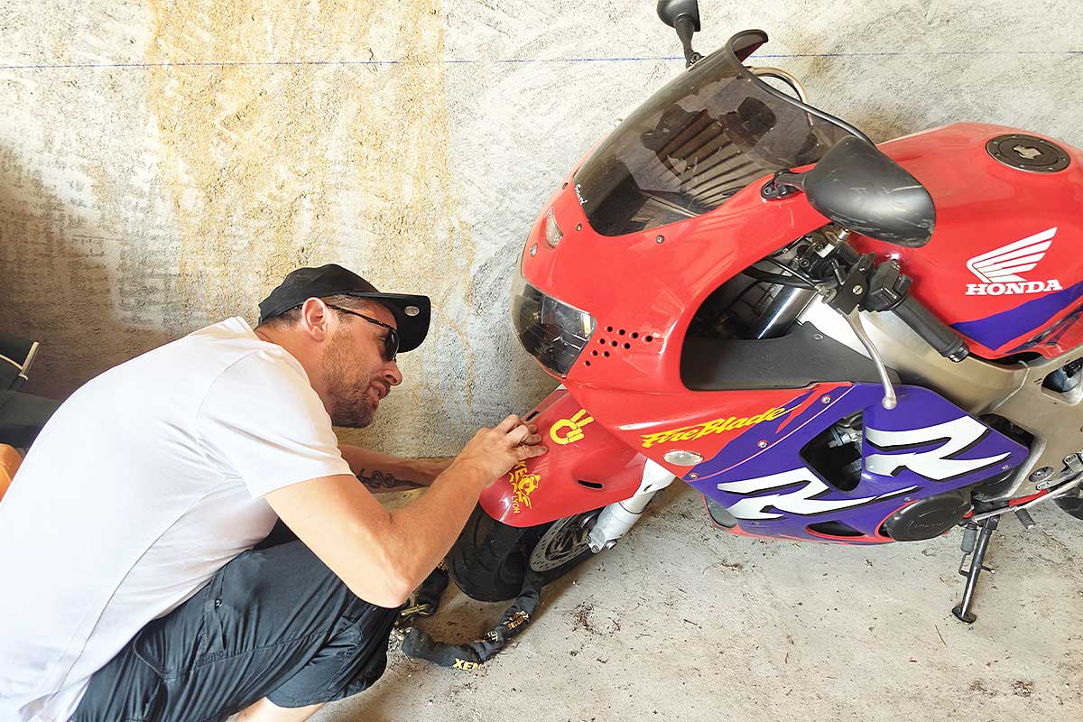 Un motard inspecte son véhicule.