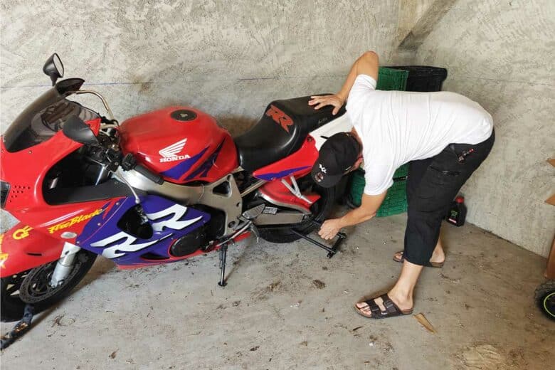 Un homme inspecte sa moto.