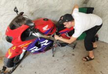 Un motard inspecte son véhicule.