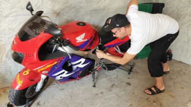 Un motard inspecte son véhicule.