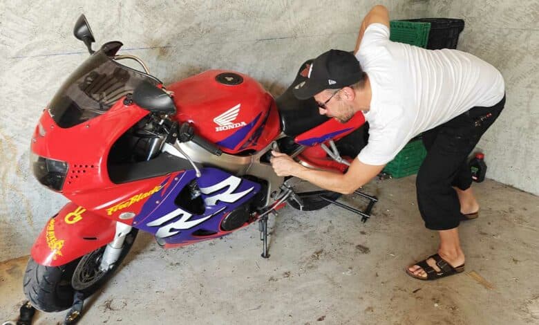 Un motard inspecte son véhicule.