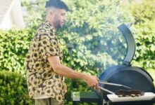 Un homme cuisine au barbecue.
