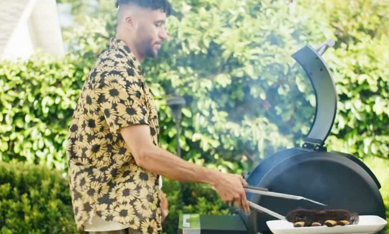 Un homme cuisine au barbecue.