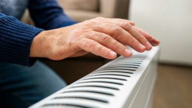Un homme passe la main au-dessus d'un radiateur.