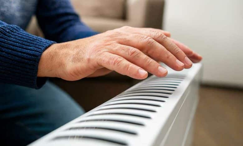 Un homme passe la main au-dessus d'un radiateur.