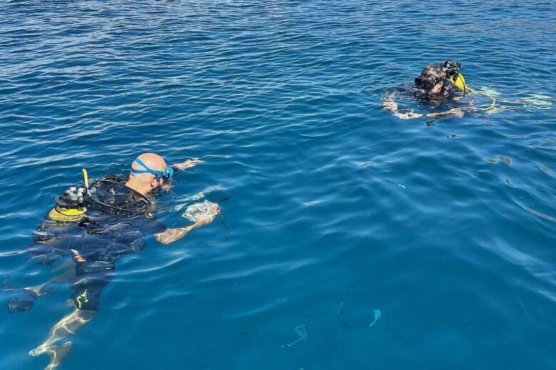Deux plongeurs communiquent dans l'eau.