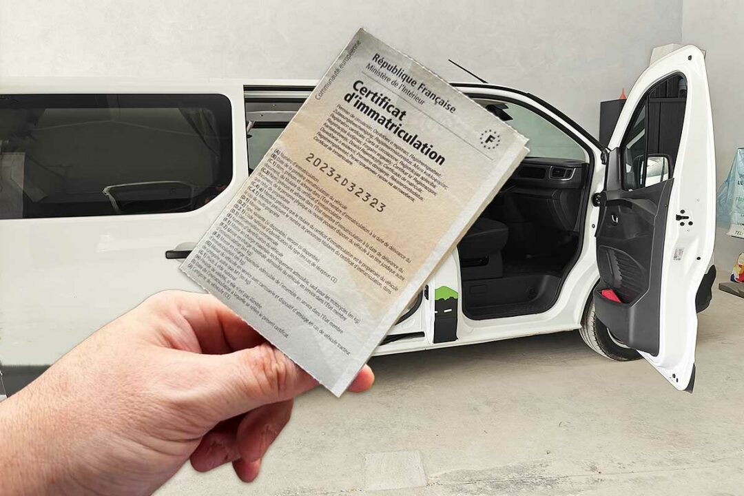 Une carte grise devant un van aménagé.