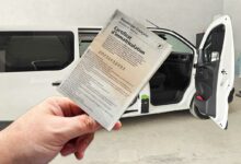 Une carte grise devant un van aménagé.