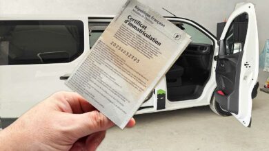 Une carte grise devant un van aménagé.