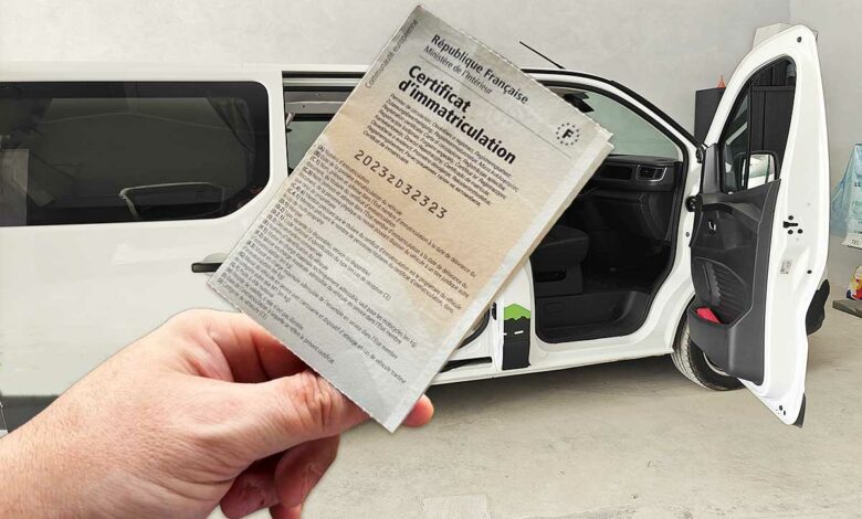 Une carte grise devant un van aménagé.