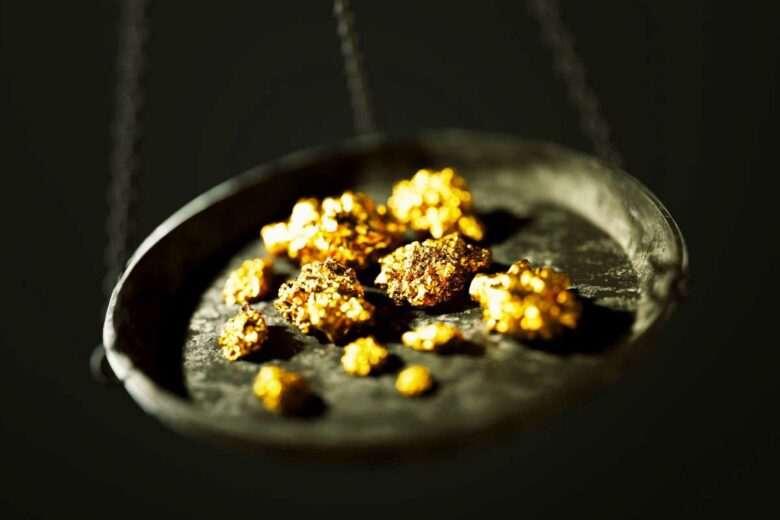 Des pépites d'or dans une balance.
