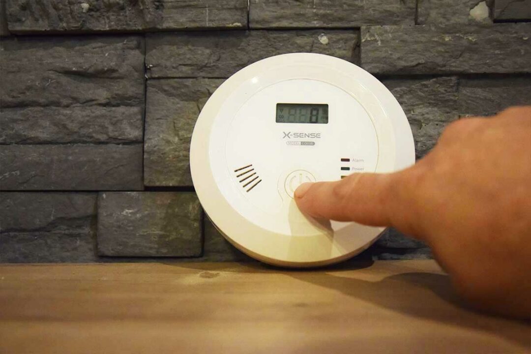 Une personne teste son détecteur de monoxyde de carbone.
