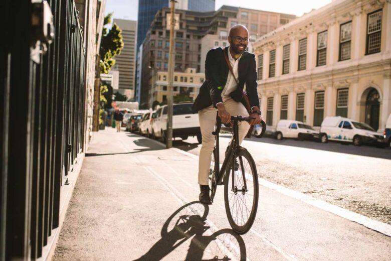 Un homme roule à vélo sur un trottoir.