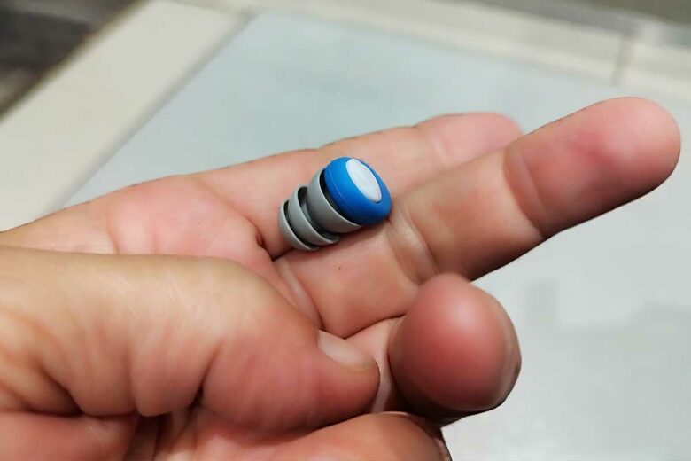 Un bouchon d'oreille dans la main.