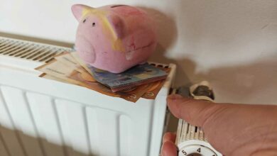 Une personne allume son chauffage avec une tirelire dessus.