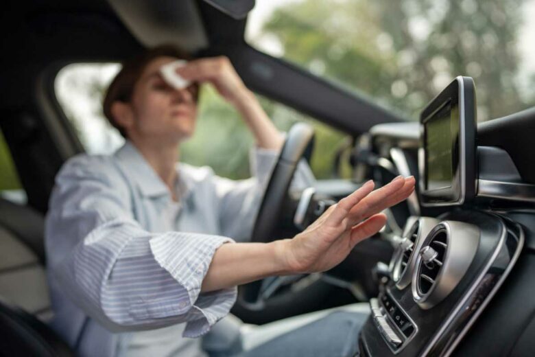 Une femme a chaud dans sa voiture.