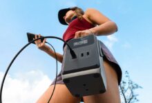 Une femme porte sa batterie nomade.