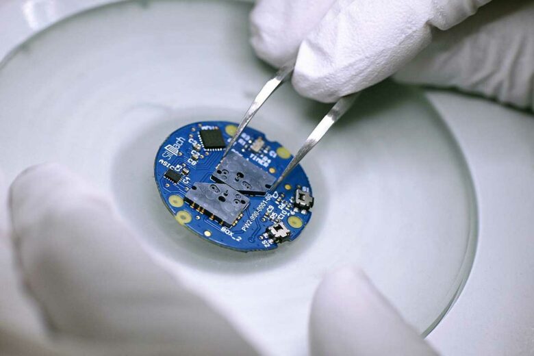 Un micromoteur en silicium installé sur une carte électronique de montre.