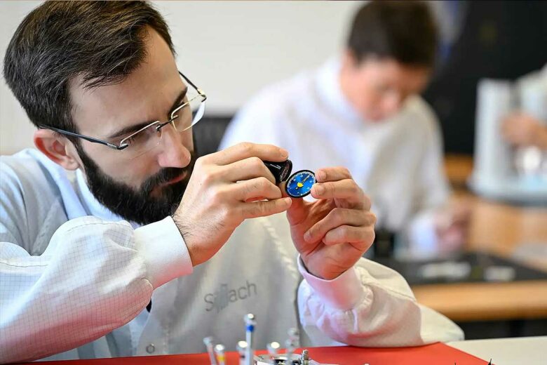 Un homme fabrique et vérifie une montre.