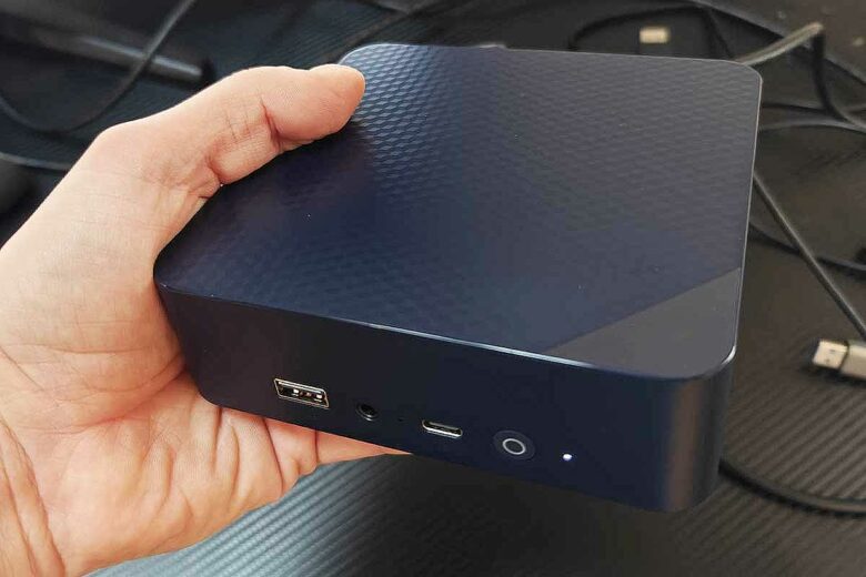 Un mini PC tenu dans une main.